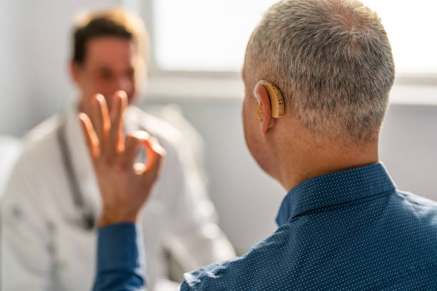 Doctor and Male Patient With Hearing Aid Doctor and Male Patient With Hearing Aid audiologist stock pictures, royalty-free photos & images