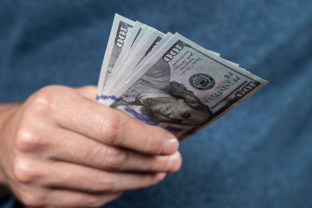 istock American 100 dollars bank note in hand close up 1473910430