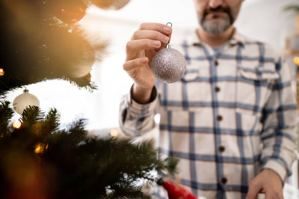 istock Unrecognizable Caucasian man decorating a Christmas tree 1473911272