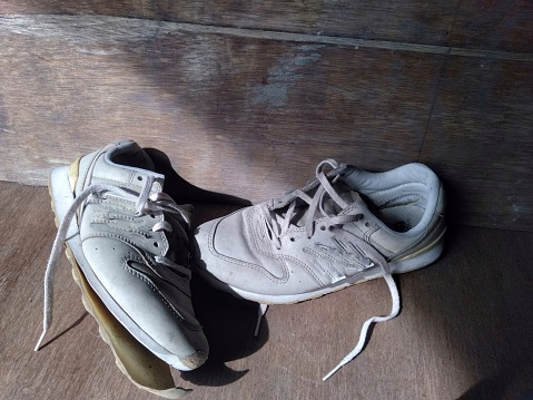 A pair of muddy sports shoes or trainers.