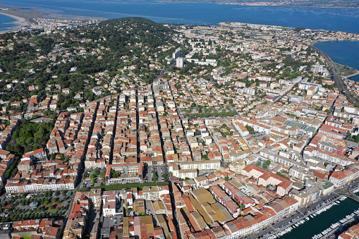 Sète is located in the region of Occitania, southern France. The image shows the city and a sea channel captured during a sunny day in spring season.