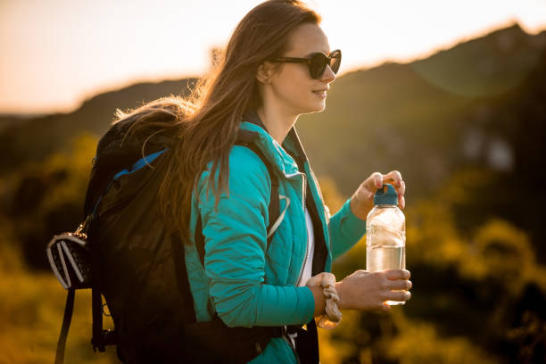 istock Young woman drinking water at sunset 1473913804