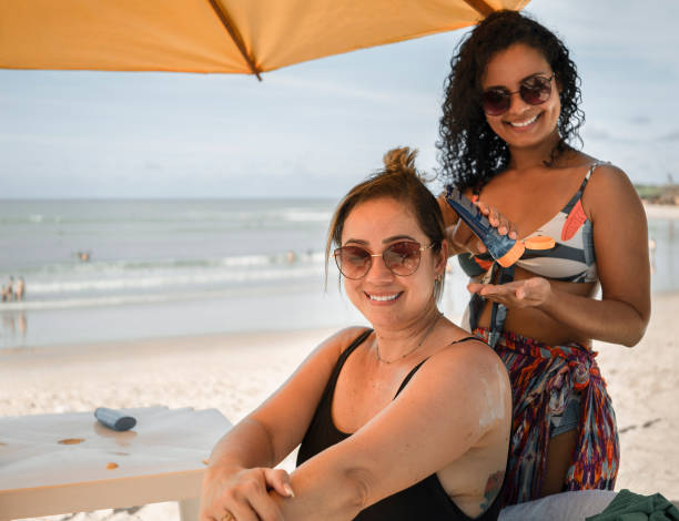 istock Women applying sunscreen on body on the beach 1473913955