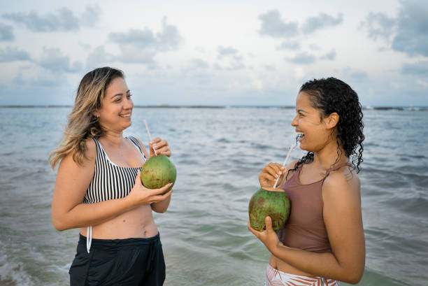 istock Woman drinking coconut water on the beach 1473914333
