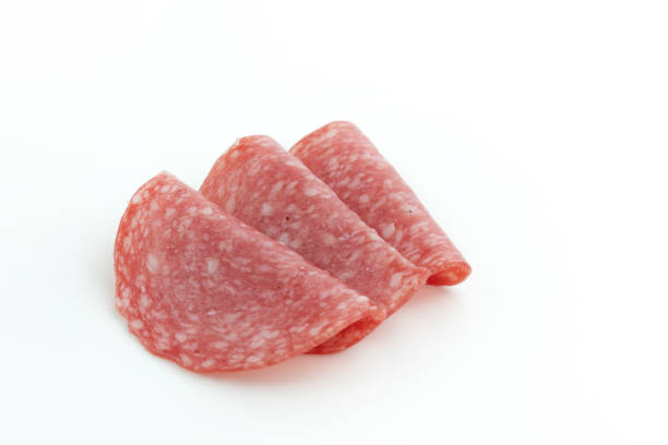 salami sausage slices isolated on white background, pieces of sliced salami sausage laid out to create layout