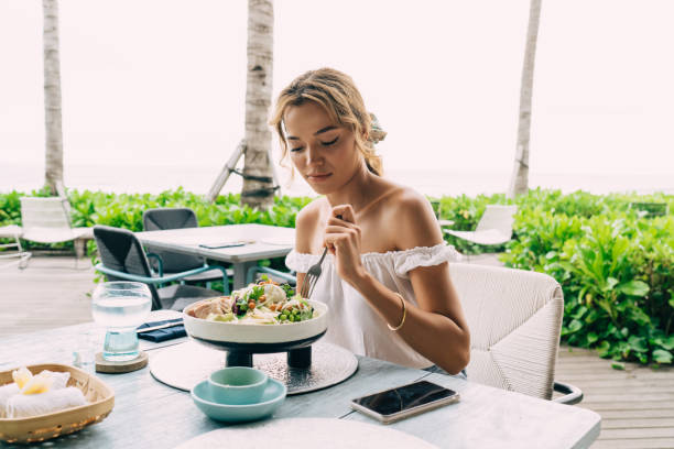 istock Woman eating salad in outdoors restaurant 1473921250