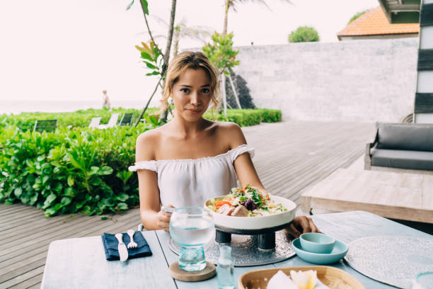 istock Young woman having lunch in outdoors cafe 1473921281
