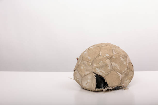 Abandoned Soccer Ball: A Tale of Neglect and Decay on a white table stock photo