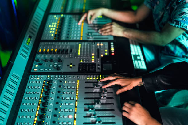istock Close up audio engineer hands working with panel mixer control in music recording studio 1473923619