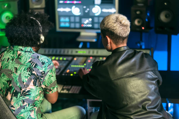 istock Young audio engineer people having fun working with mixer sound panel control in music recording studio 1473924464