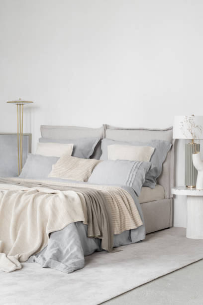 istock Cozy bed in bright bedroom in blue and beige 1473926888