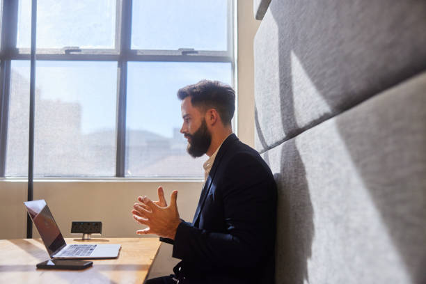 istock Businessman talking on a laptop video call while working in a bright office 1473927402