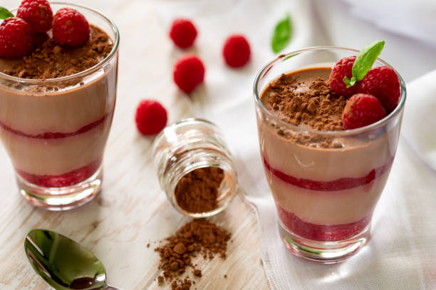 Succulent cocoa and raspberry dessert, decorated with cocoa powder and mint