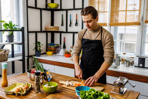 istock Young man learning cooking at home 1473927576