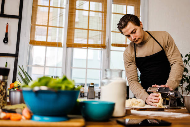 istock Handsome chef makes homemade Italian traditional pasta 1473928262