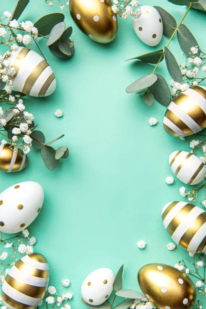 istock Easter eggs painted in gold and eucalyptus branches on a soft green background. 1473928285