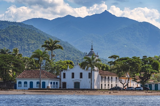 Paraty, Brazil. Our Lady of Sorrows church seen from the sea. Historic downtown. Colonial city founded in 1667. National Historic Heritage. In the background, the mountains of Serra da Bocaina.