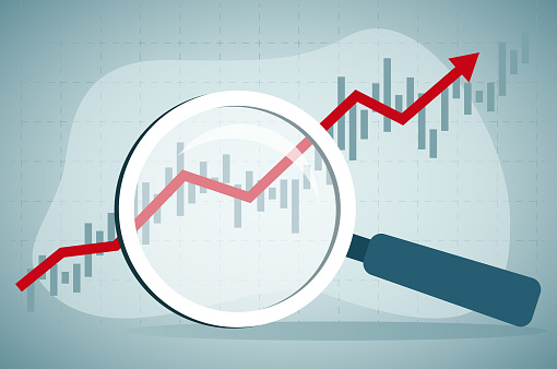 Using magnifying glass to look at rising stock market data