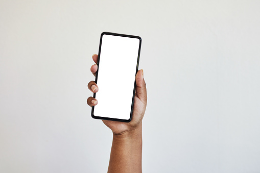 Hand, phone and blank screen with mockup, zoom on black woman hands in studio isolated on white background. Technology, connect and empty space on smartphone for website, social media or advertising.