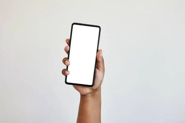 Hand, phone and blank screen with mockup, zoom on black woman hands in studio isolated on white background. Technology, connect and empty space on smartphone for website, social media or advertising.