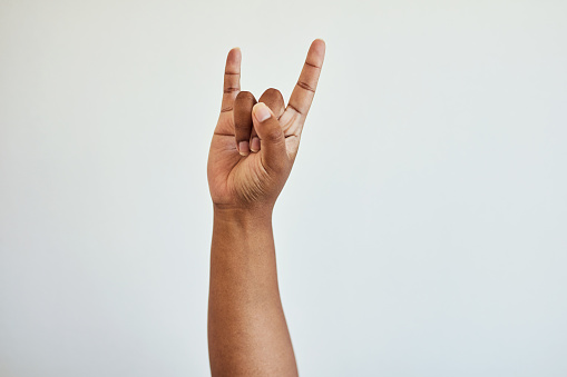 Symbol, rock and roll and hand on a white background for music, sign language and gesture. Communication, emoji and isolated palm with pinky, fist and thumb for punk culture, heavy metal and horns
