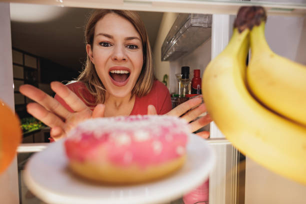 istock Woman Looking At Donut In Refrigerator 1473933652
