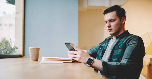 istock Serious man surfing internet on smartphone in cafe 1473934231