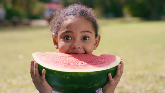 African girl child, watermelon and park for eating, nutrition and happiness in summer sunshine on holiday. Happy female kid, fruit and portrait with food, freedom and excited for adventure in nature