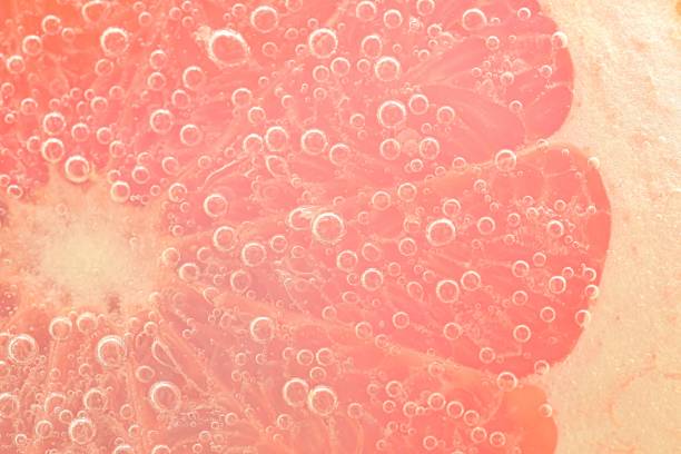 istock Red grapefruit slice floating in club soda. Fresh grapefruit slice with bubbles in carbonated drink. Fresh natural red grapefruit slice coverd by bubbles 1473939527