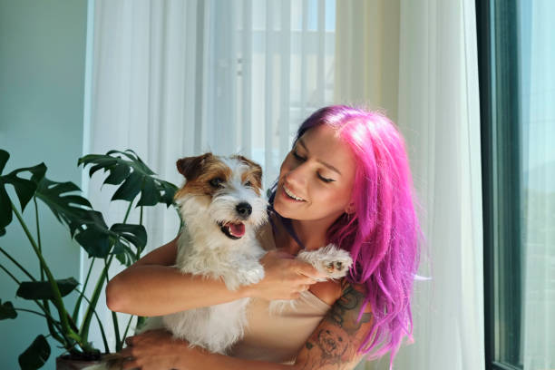 istock Alternative model with multicolored hair hugging a hairy dog. 1473941243