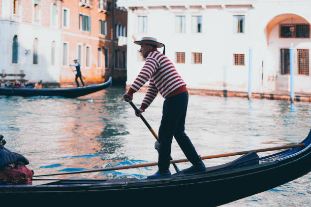 Gondolier The Gondolier of Venice is an expert gondola driver, who offers a romantic ride along the canals of the city while telling stories and curiosities about Venice. gondolier stock pictures, royalty-free photos & images