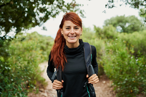 Pretty redhead hiker on her way to the top