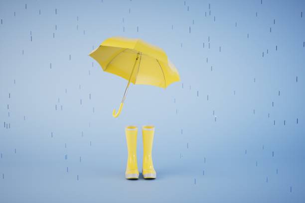 istock rainy spring. an open umbrella and yellow rubber boots on a blue background. 3D render 1473950161