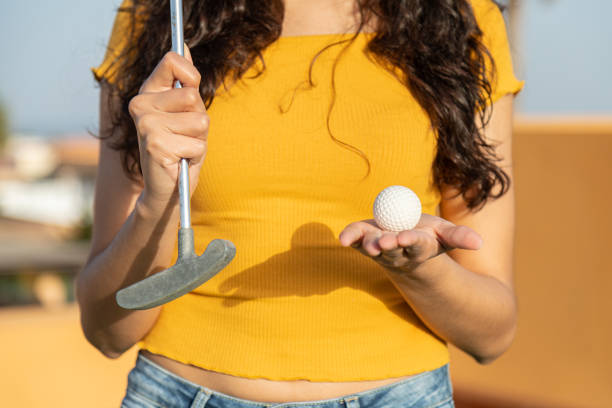 урожай неузнаваемой женщины-гольфистки, показывающей клюшку для гольфа и мяч - golf golf swing putting cheerful стоковые фото и изображения