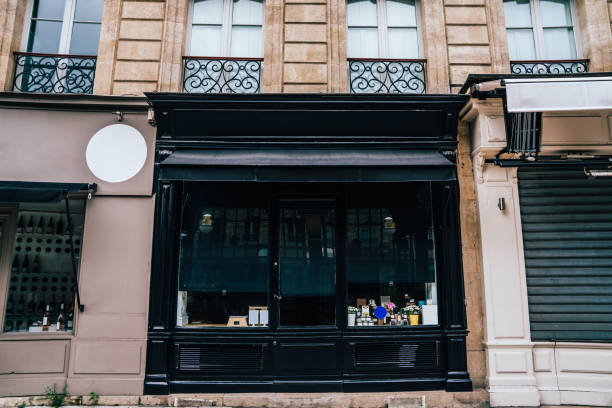 From below of modern shop with goods behind storefront in front of historic building with French balconies in downtown of Bordeaux