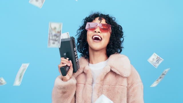 Winner, cash gun and woman isolated on blue background with cannon lottery, bonus or winning prize. Face of rich black person in financial freedom, wealth power or money rain in air in studio success