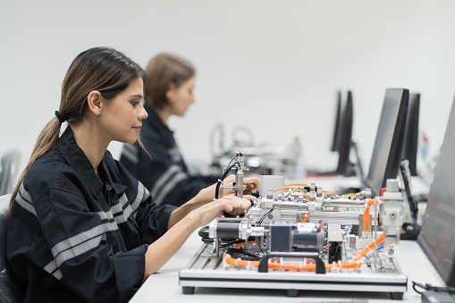 Female engineer using desktop computer for training Programmable logic controller in the manufacturing automation and robotics room