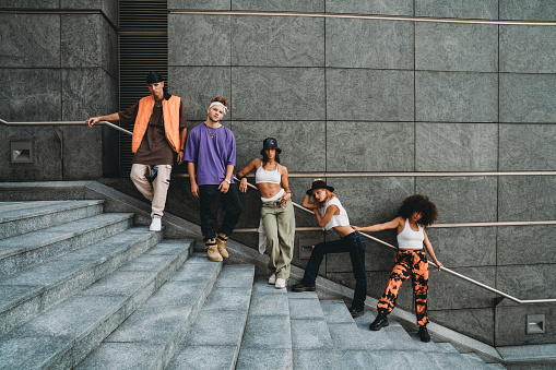 Young adult dancers in the city on a modern staircase. Five multi ethnic people. They are dancers with cool attitude.