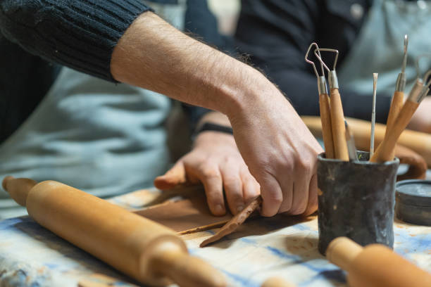 istock Close up of human hands making a clay mug. Pottery teaching class. Potter makes dishes from clay, ceramics. 1473957757