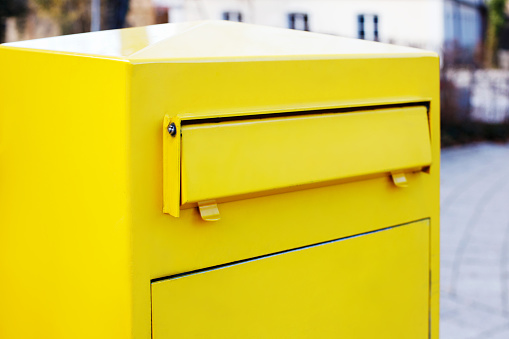 close-up yellow mailbox for letters and newspapers