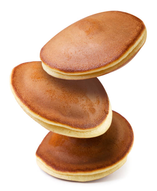 Pancakes flying close up on a white background.