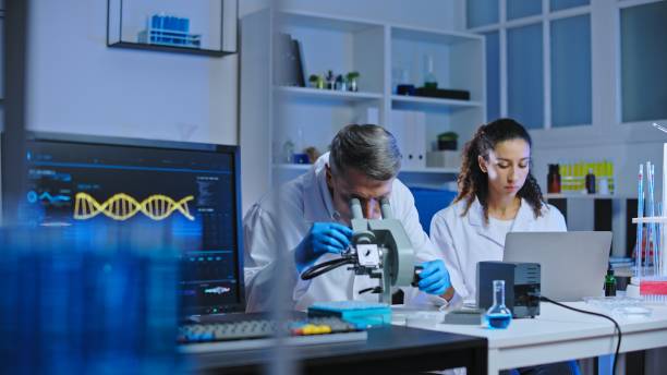 istock Lab researchers examining biological material under microscope, drug development 1473961982