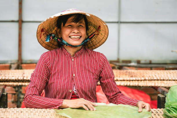 portrait of happy vietnamese woman in rice noodle manufacture stock photo