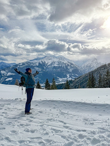 Middle aged man hiking high up in the European Alps mountains on a sunny winter day. 
Shot with iPhone 14 Pro