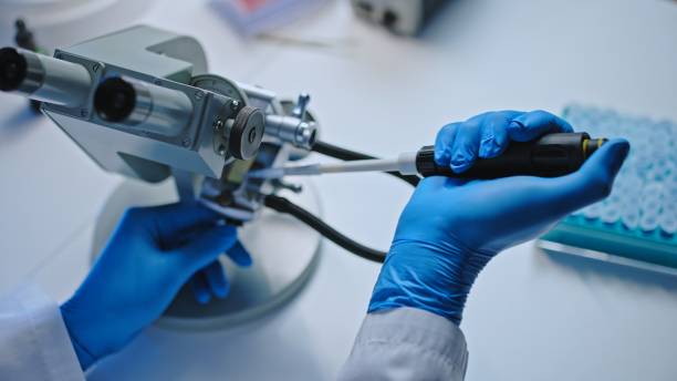 istock Male scientist examining liquid chemical substance under microscope, lab research 1473962450