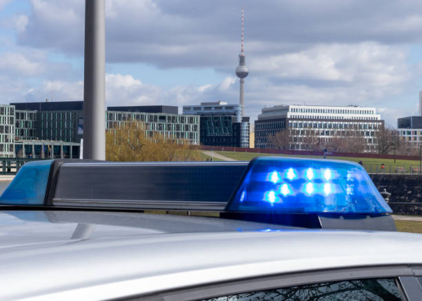 Police Car With Blue Flash Light  Against City Skyline