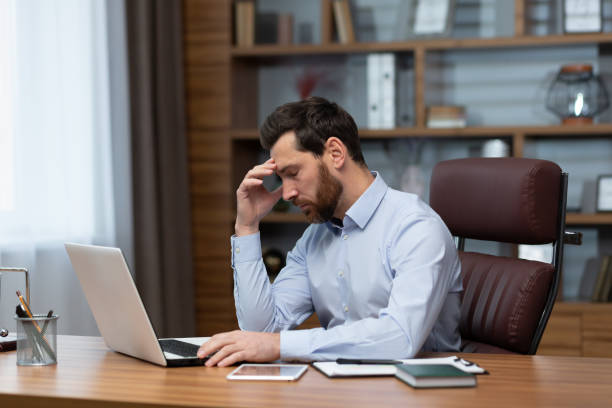 istock Mature pensive sad businessman working inside office, boss using laptop at work thinking about difficult decision in shirt 1473968776