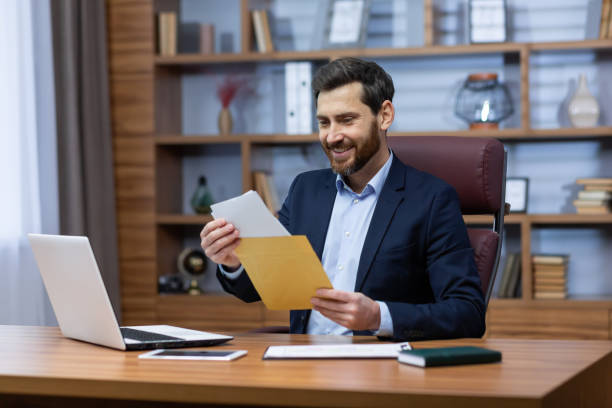 istock Successful mature man inside office at work, senior man with beard in home office received mail fox, bank notification, businessman reading good news in envelope, satisfied with achievement results 1473968939