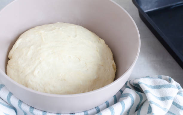 istock A bowl with dough and a cooking spatula on the table. The process of making Pampushky, traditional Ukrainian buns for borsch. The concept of traditional dishes. Homemade baking. Horizontal orientation 1473973382