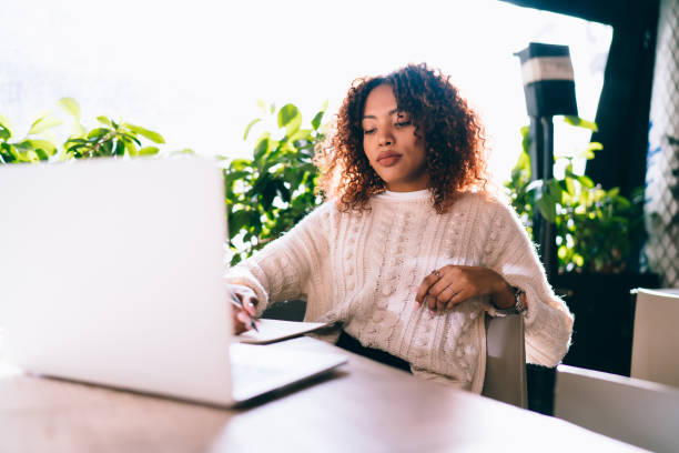 istock Thoughtful ethnic woman taking notes in planner 1473975605
